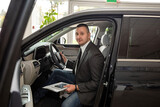 Man customer buyer in suit choosing best new car at dealership