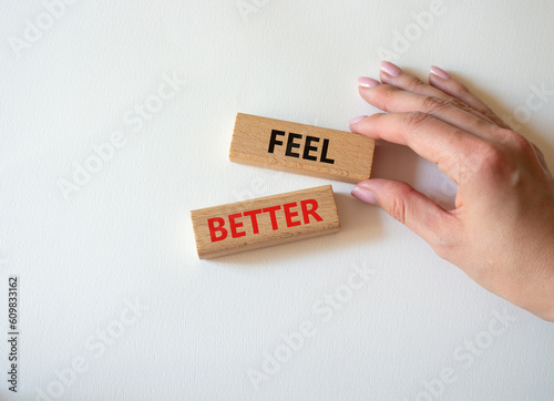 Feel better symbol. Wooden blocks with words Feel better. Businessman hand. Beautiful white background. Business and Feel better concept. Copy space.