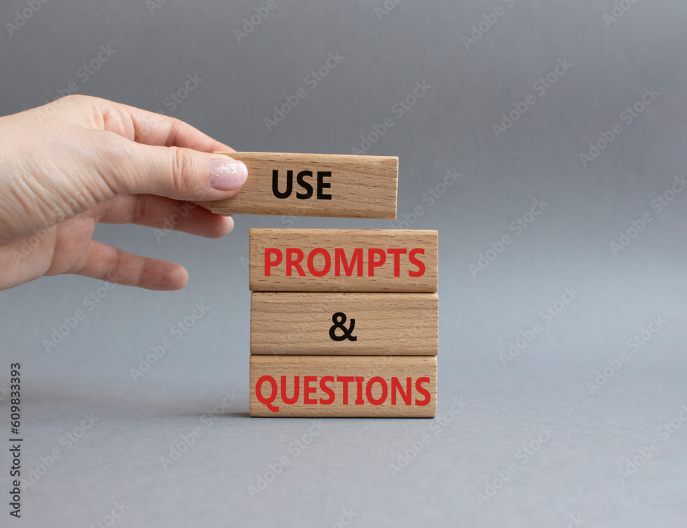 Prompts and Questions symbol. Concept word. Use Prompts and Questions on wooden blocks. Beautiful grey background. Businessman hand. Business and Prompts and Questions concept. Copy space Prompts and Questions symbol. Concept word. Use Prompts and Questions on wooden blocks. Beautiful grey background. Businessman hand. Business and Prompts and Questions concept. Copy space