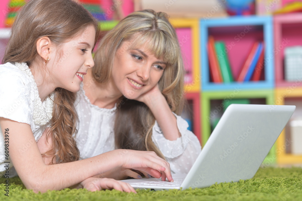 mother and daughter looking at laptop computer mother and daughter looking at laptop computer