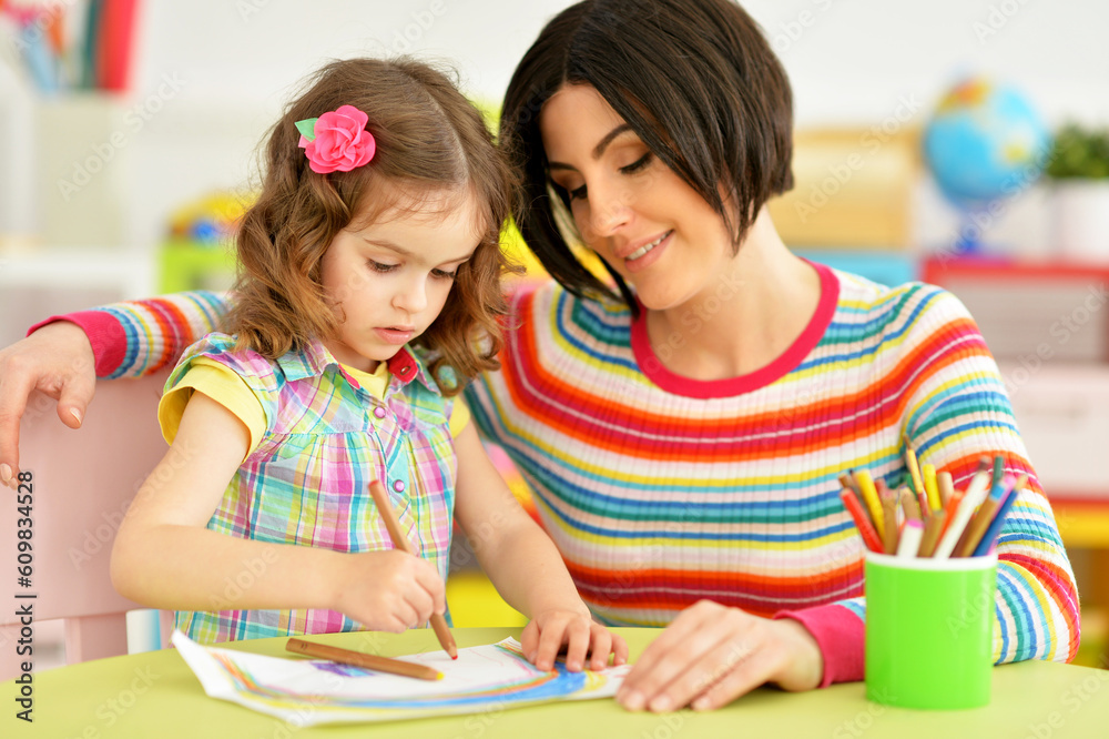 Fototapeta premium little cute girl with mother drawing at the table at home