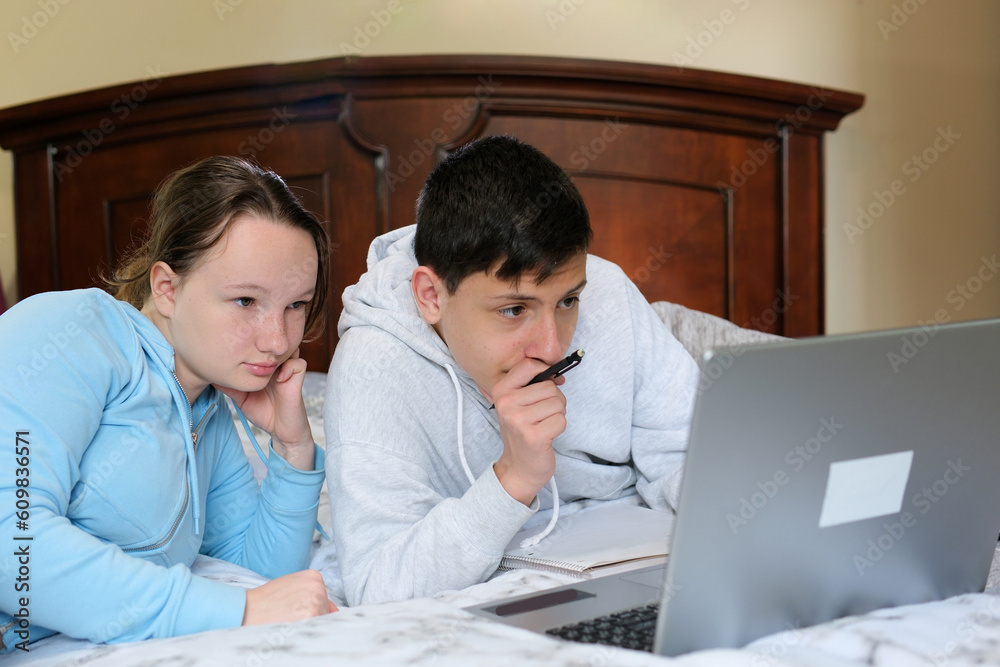 online learning teenagers boy and girl sitting near laptop and doing homework watching movie friends Classmates bedroom bed smile like each other First love online learning teenagers boy and girl sitting near laptop and doing homework watching movie friends Classmates bedroom bed smile like each other First love