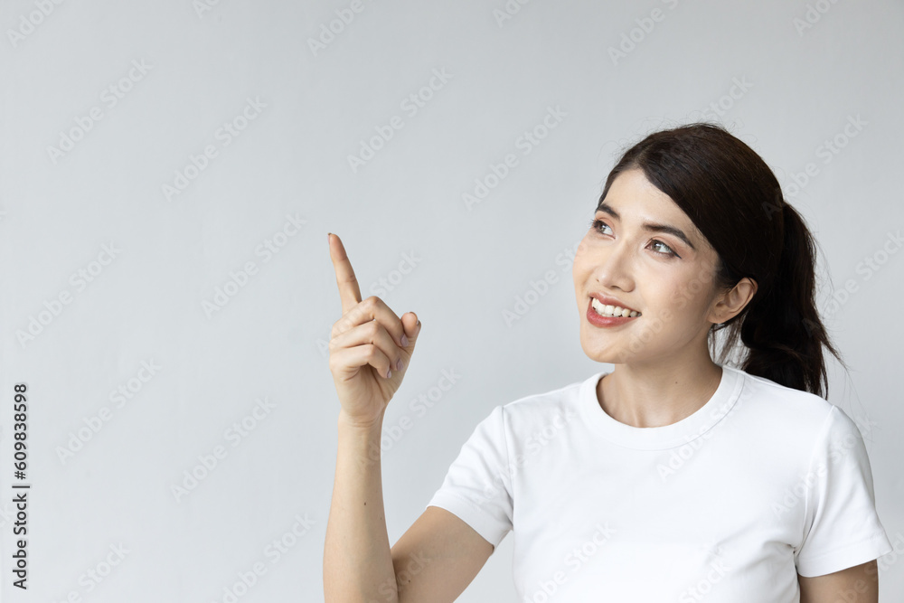Happy smiling asian woman pointing up on isolated background Happy smiling asian woman pointing up on isolated background