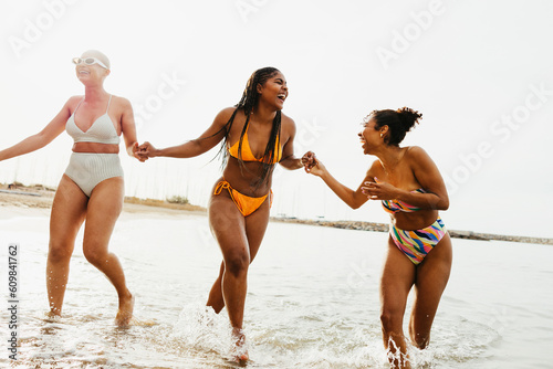 Playful friends in swimwear enjoying in sea photo