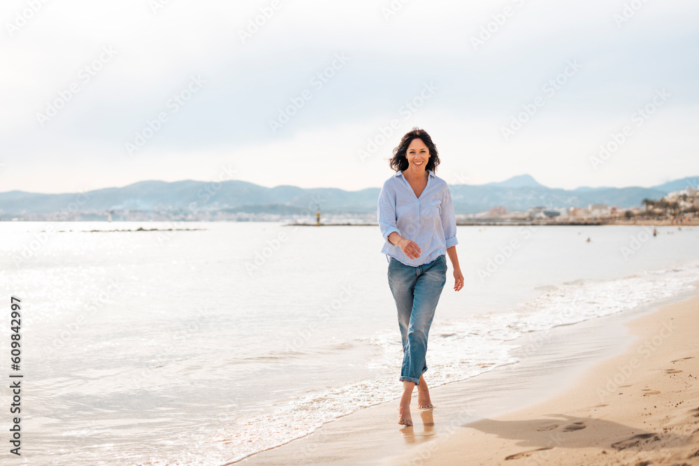 Happy woman walking near sea at beach Happy woman walking near sea at beach