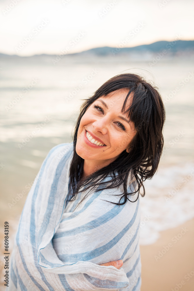 Happy woman wrapped in scarf and enjoying at beach Happy woman wrapped in scarf and enjoying at beach