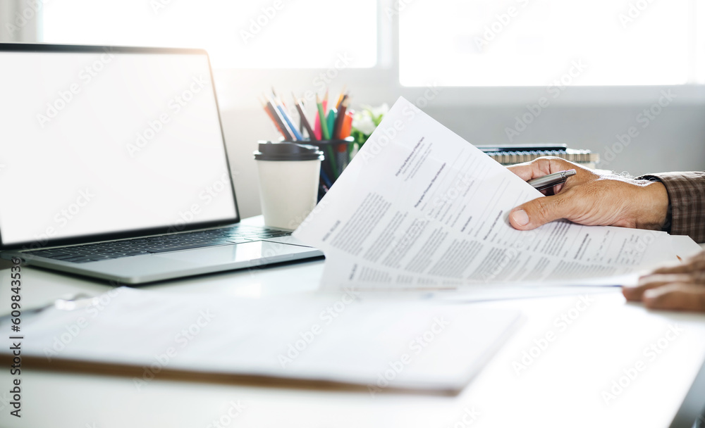 Businessman working on laptop reviewing document reports reading email and meeting online. legal expert, professional lawyer reading and checking financial documents or insurance contract Businessman working on laptop reviewing document reports reading email and meeting online. legal expert, professional lawyer reading and checking financial documents or insurance contract