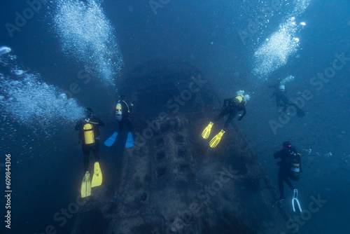 Friends scuba diving and examining sunken ship El Naranjito undersea photo