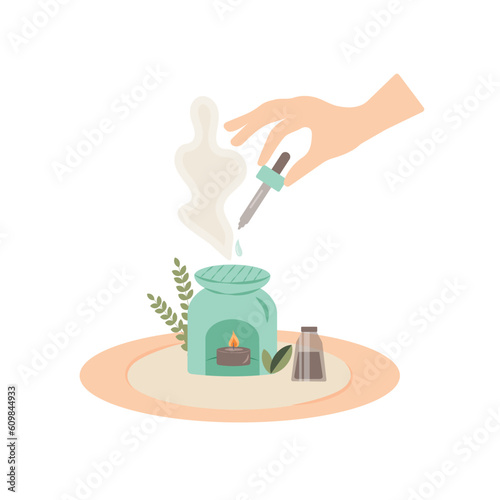 Female hand holding pipette with essential oil and dripping oil into an aroma lamp.