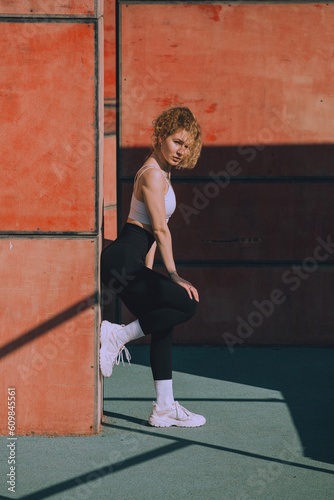 A young woman is doing sports in the open air in the middle of the sports ground