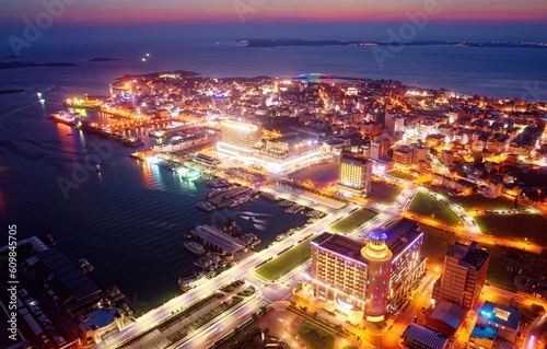 Aerial view of Magong seaport at sunset, the capital city of Penghu County, Taiwan, with ships parking in the harbor, city lights dazzling at dusk and the horizon tinted by the beautiful twilight sky