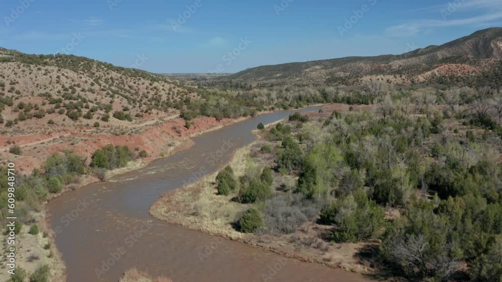 Aerial over swollen river flowing through arid desert landscape in spring Aerial over swollen river flowing through arid desert landscape in spring