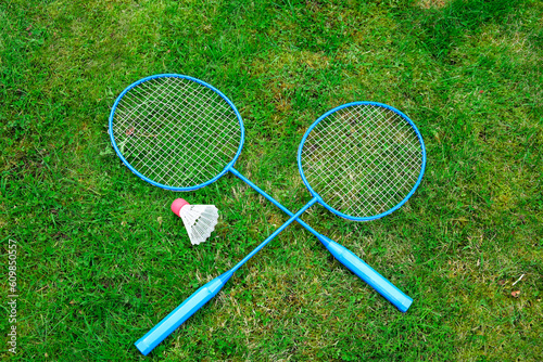 Badminton game rackets and shuttlecock on grass. High quality photo
