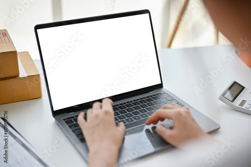 Close-up image of a female online business owner confirming orders on the website