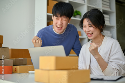 Cheerful Asian couple, online business owners are showing their fists and celebrating their success © bongkarn
