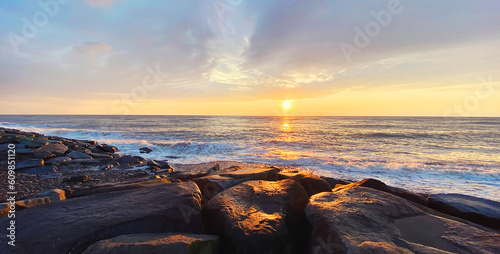 Seascape, sea landscape with waves and rocky coast at sunny sunset in the evening
