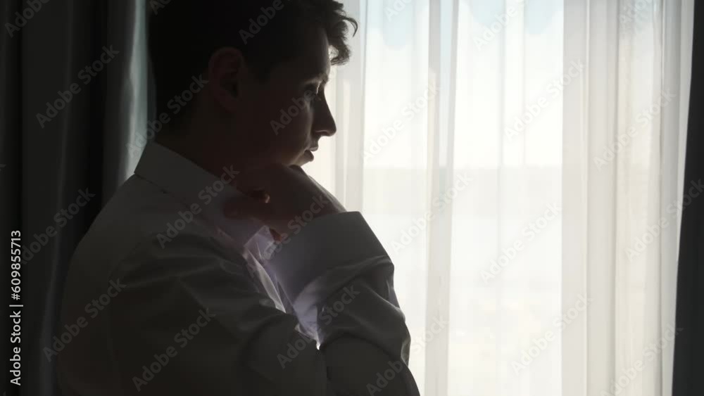 Slow motion of handsome young man is dressing a white shirt for going to work in his bedroom. Slow motion of handsome young man is dressing a white shirt for going to work in his bedroom.