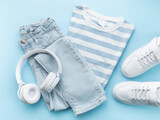 Child's t-shirt, shoes and headphones on blue backgrund