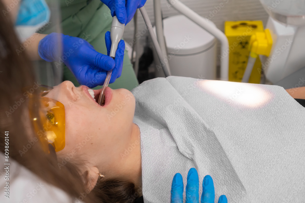 Closeup woman patient. Carious tooth treatment at dental clinic office