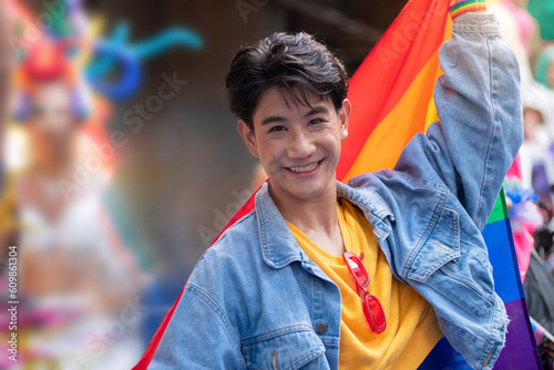 LGBTQ men enjoy celebrating Pride by raising rainbow flags and waving them in the annual Pride Parade, celebrating LGBT pride month parade   photo