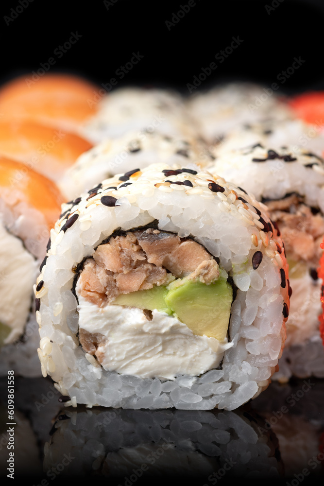 Traditional delicious fresh sushi roll set on a black background