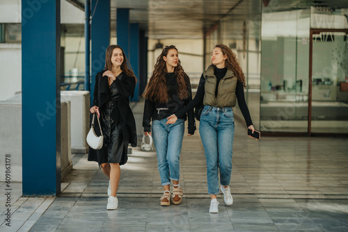 Three beautiful girls walking at the shopping center and having a conversation