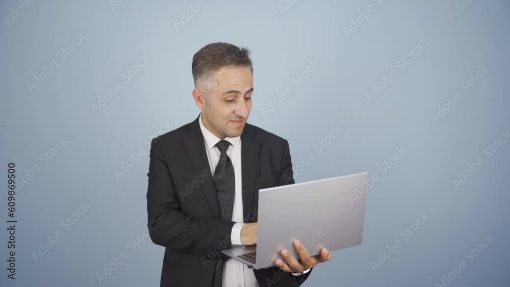 Satisfied businessman looks at laptop and approves. Satisfied businessman looks at laptop and approves.