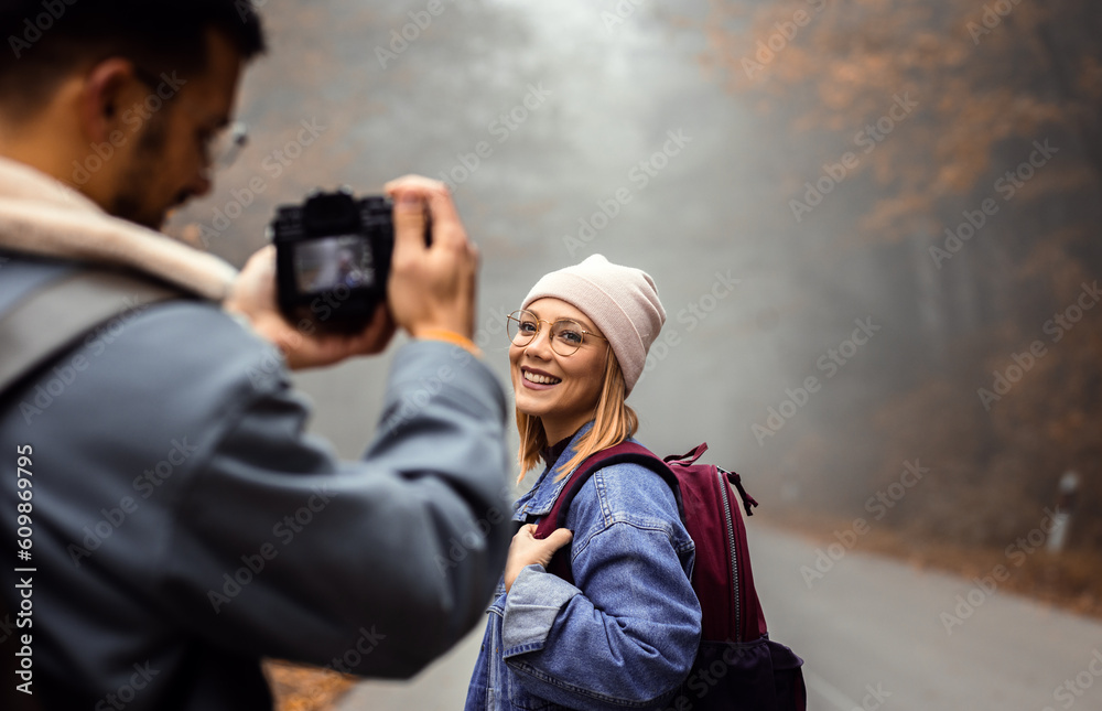Couple spending time together walking on forest road on photographing each other a foggy morning. Couple spending time together walking on forest road on photographing each other a foggy morning.
