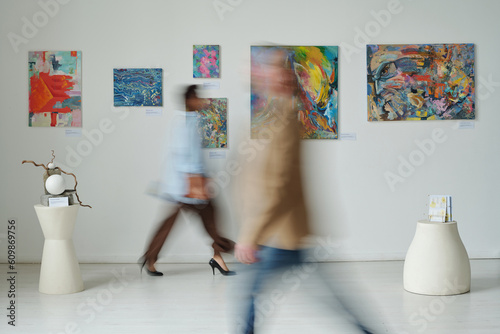 Fotografija Blurred motion of people visiting art gallery, they walking along the hall among