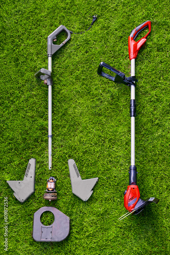Fotografija New and old taken apart Lawn trimmer with visible rusty motor