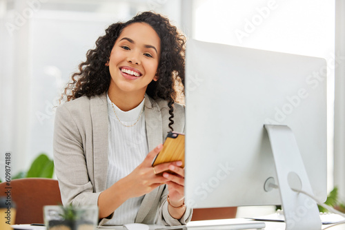 Computer, phone and portrait of insurance agent or business woman on social media, internet or web in a startup. Happy, online and employee or entrepreneur working on agency project in office photo