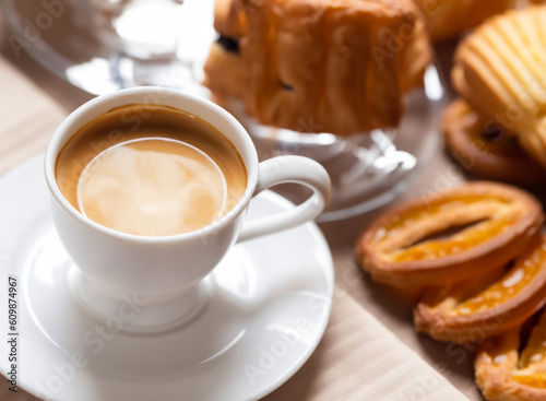 Tazzina di caffé espresso e pasticcini. Generative AI image. photo
