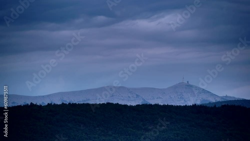 Time lapse. Clouds moving in the evening over mountain landscape with Mont Ventoux in the distance, view from Baronnies Provencales Natural Park in France. photo