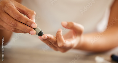 Finger, diabetes and a person checking their blood sugar level in a home closeup for routine treatment. Hands, test and medical equipment with a diabetic adult taking a sample to check glucose