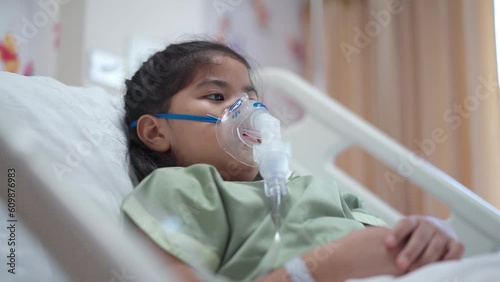 Asian girl 7 year old in hospital using inhaler containing medicine, RSV, Respiratory Syncytial Virus photo