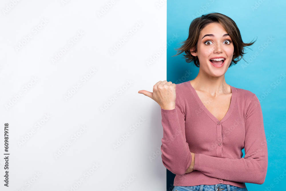 Portrait of optimistic impressed girl pink cardigan astonished staring directing at empty space offer isolated on blue color background Portrait of optimistic impressed girl pink cardigan astonished staring directing at empty space offer isolated on blue color background