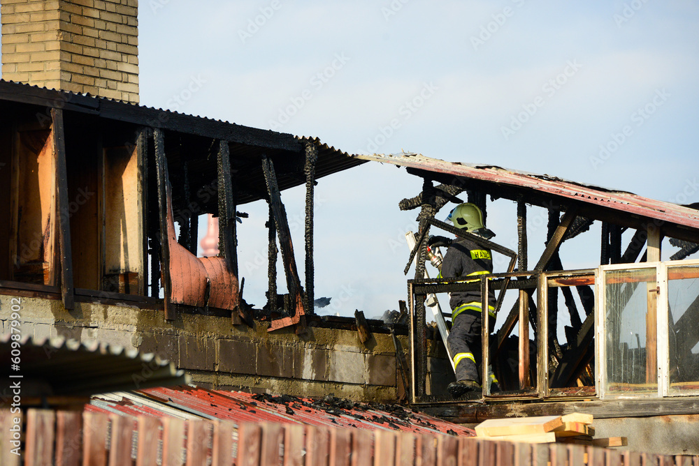 Strong and brave firefighters on burning house are trying to extinguish open fire. Liptovsky Mikulas, Slovakia. Strong and brave firefighters on burning house are trying to extinguish open fire. Liptovsky Mikulas, Slovakia.