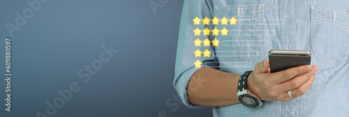 Man holding smartphone device and touching screen with five star rating feedback