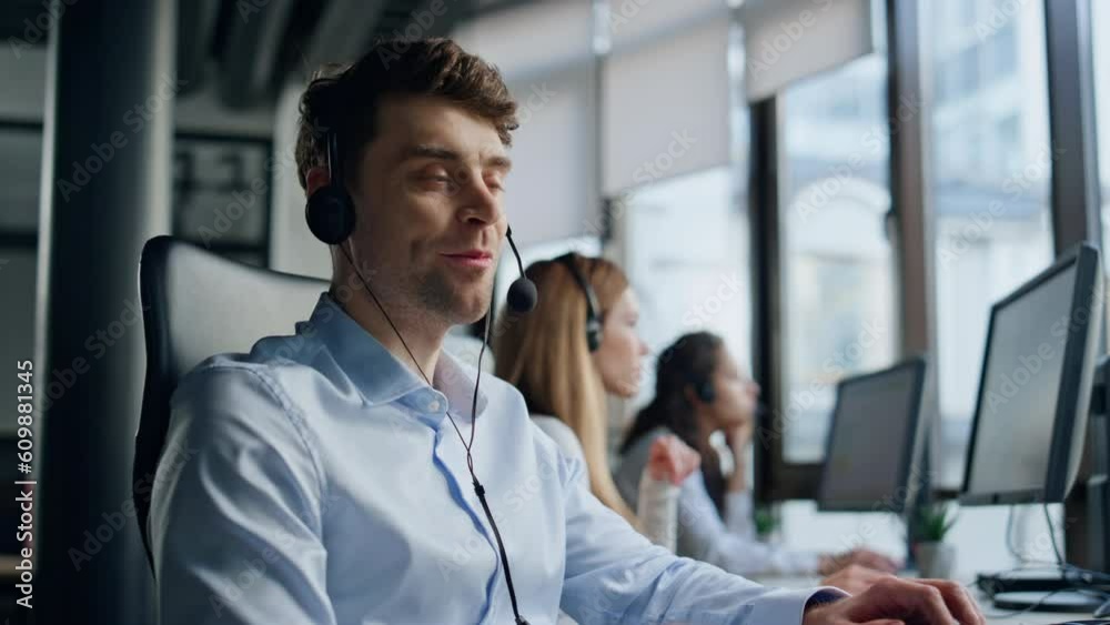 Call center operator talking headset in data office. Friendly man representative