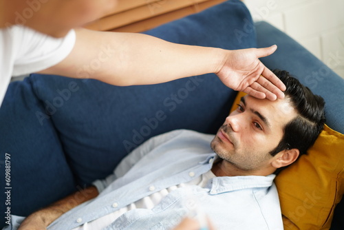 gay man sleeping with sickness on Sofa while boyfriend take care. Diversity of LGBTQ relationships. A gay couple living together concept