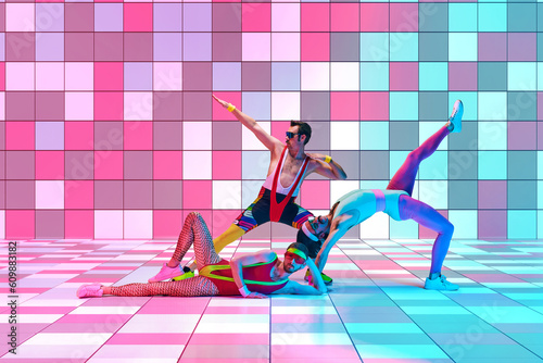 Stylish sportsmen in colorful sportswear doping exercises, stretching against multicolored mosaic studio background in neon light. Concept of sportive and active lifestyle, humor, retro style. Ad