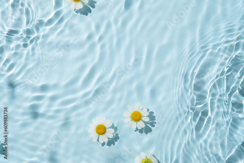 Chamomile flowers are floating, stains from a drop on the water