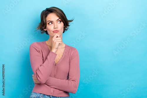 Photo of young ponder thoughtful woman wear trendy pink top touch chin look empty space distrust minded isolated on blue color background photo