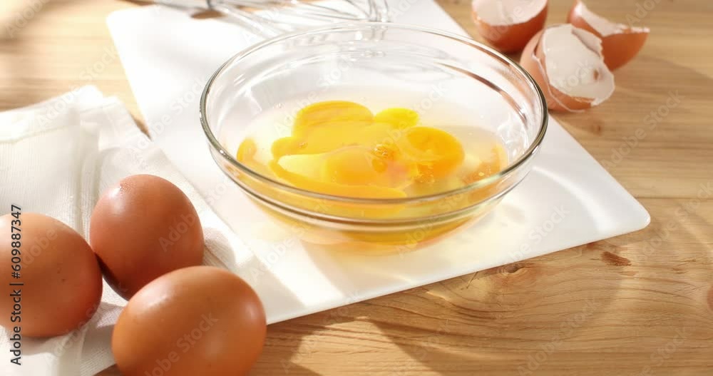 Cracked eggs. Raw egg pours into bowl. Breakfast preparation. Rustic style. Sunny day. Smooth camera movement. Close up. 4k footage. Cracked eggs. Raw egg pours into bowl. Breakfast preparation. Rustic style. Sunny day. Smooth camera movement. Close up. 4k footage.