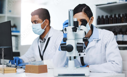 Science, laboratory and team of scientists with microscope for research, medical analysis and lab test. Healthcare, biotechnology and man and woman with equipment for sample, experiment and virus