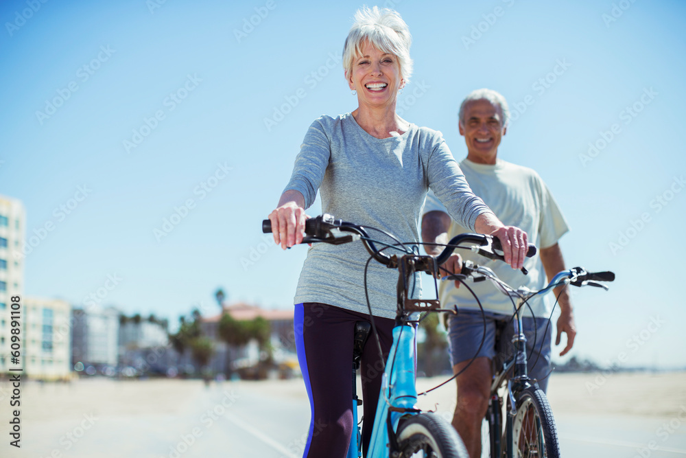 Obraz premium Portrait of senior couple with bicycles on beach boardwalk