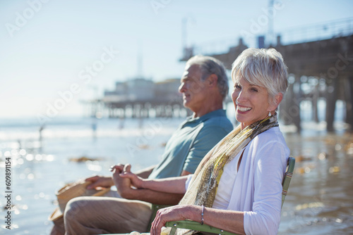 Portrait of senior couple relaxing in lawn chairs on beach © KOTO