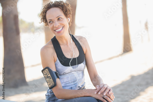 Smiling woman in sportswear wearing arm band