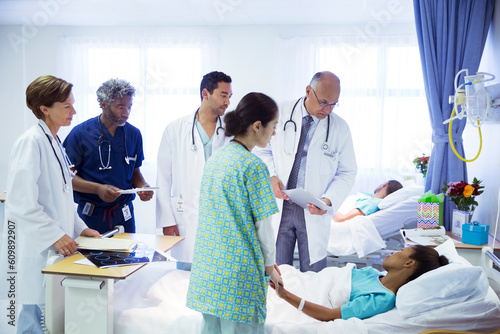 Doctors and nurse making rounds in hospital room