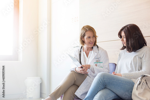 Bild auf Leinwand Doctor and patient reviewing medical record in clinic lobby